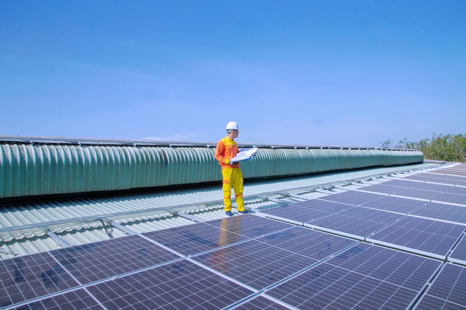 Solar technician inspecting photovoltaic panels on a roof; illustrative installation photograph