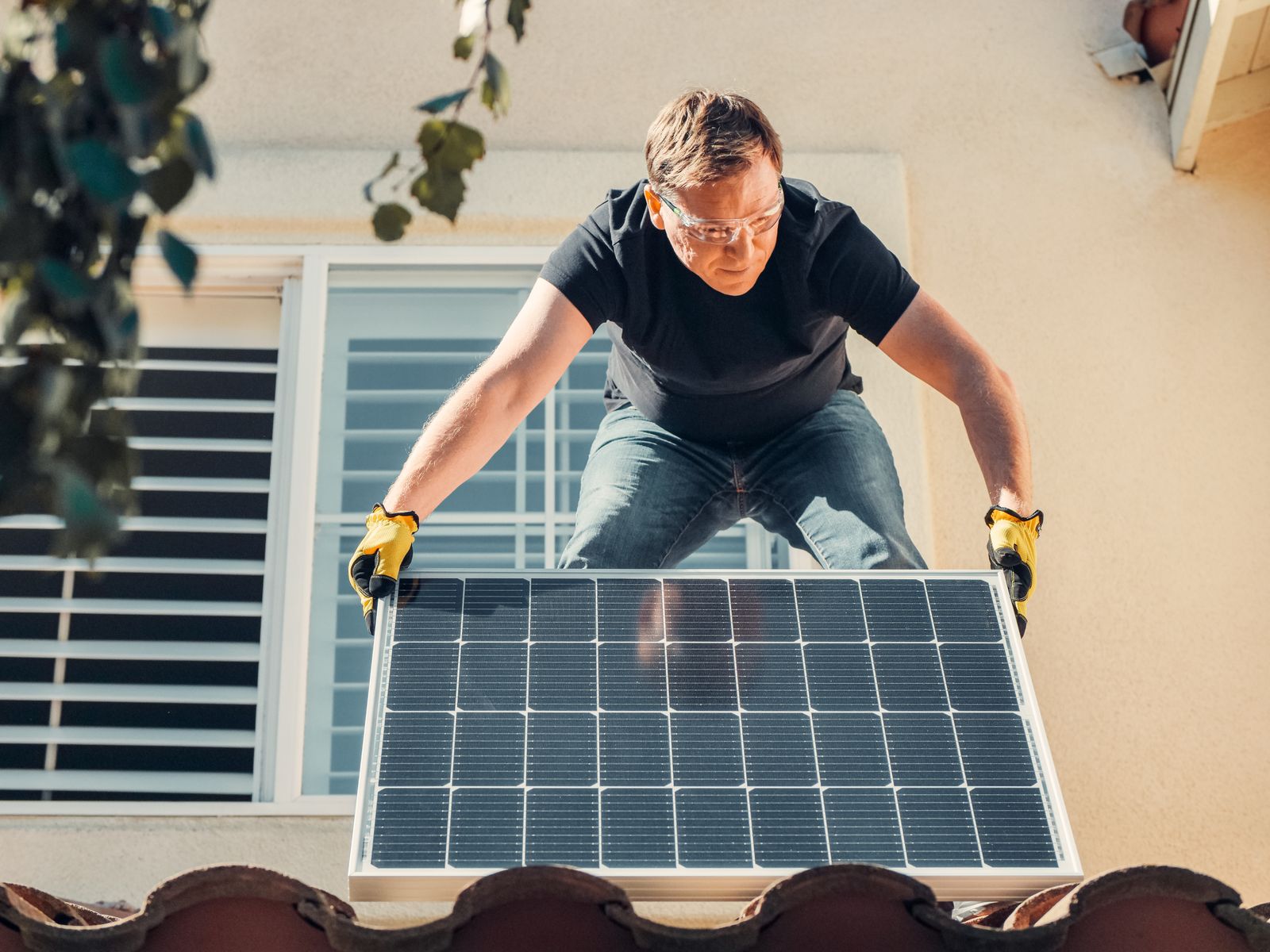 Installer working on a rooftop solar panel; illustrative stock photograph, not an identified Irish new build