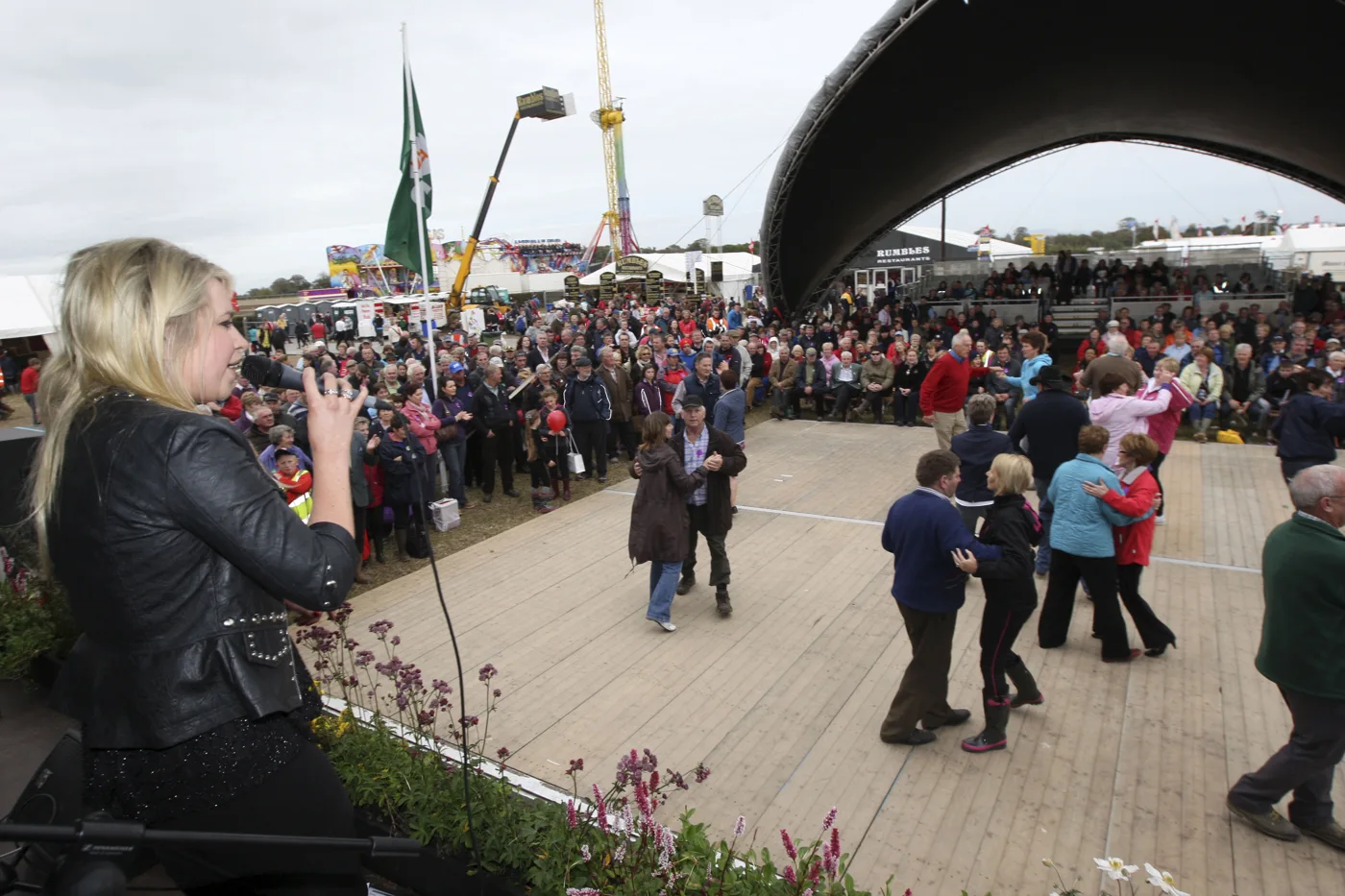 Couples dancing beside the bandstand while a singer performs and visitors watch at the Ploughing Championships.