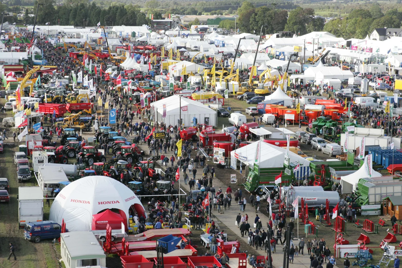 Crowds walking between machinery displays and exhibition tents at the National Ploughing Championships.